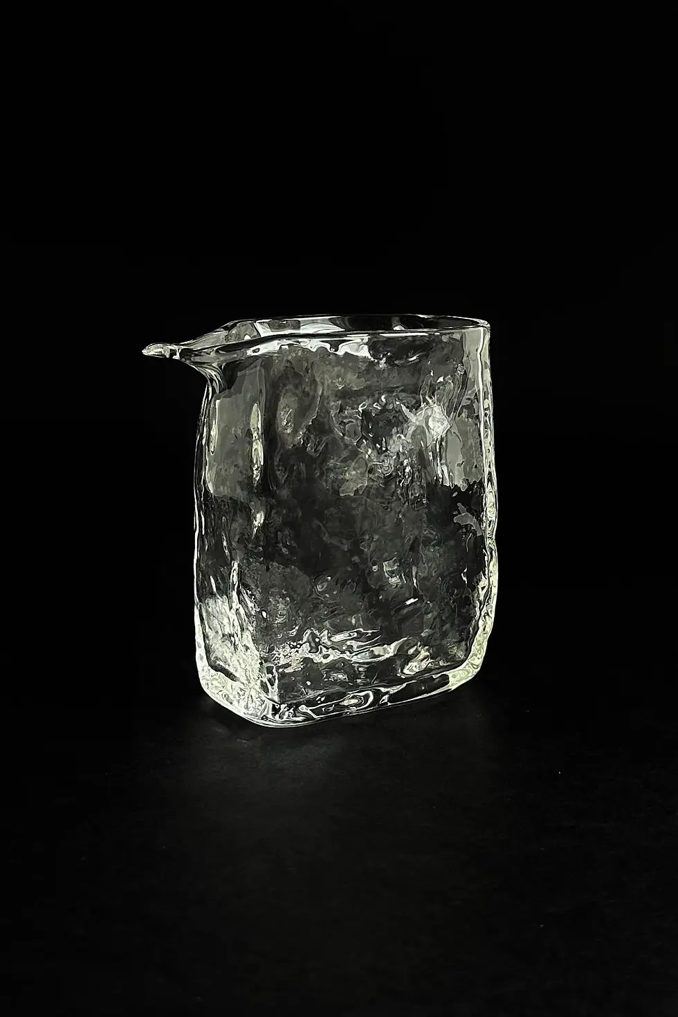 Small hammered glass pitcher with sculptural design for serving milk, tea, or cream