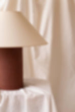Designer ceramic table lamp featuring a handmade brown stoneware base and sculptural linen shade