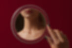 Woman looking in a handheld mirror