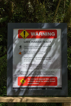 Warnschild am Lake Marian Track weist auf den anspruchsvollen Tramping Track im Fiordland Nationalpark hin.