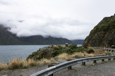 Straße entlang des Lake Wakatipu mit wolkenverhangenen Bergen auf dem Weg von Queenstown nach Te Anau.