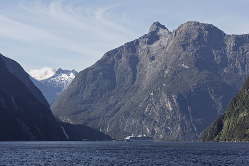 Berglandschaft und Kreuzfahrtschiff im Milford Sound im Fiordland Nationalpark auf Neuseelands Südinsel