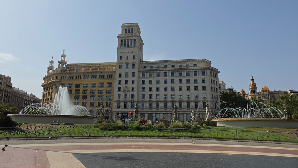 Plaça de Catalunya mit Brunnen, historischen Gebäuden und dem Hotel Iberostar Barcelona.