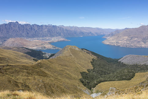 Aussicht vom Ben Lomond Track über Queenstown und den Lake Wakatipu zwischen goldbraunen Berghängen