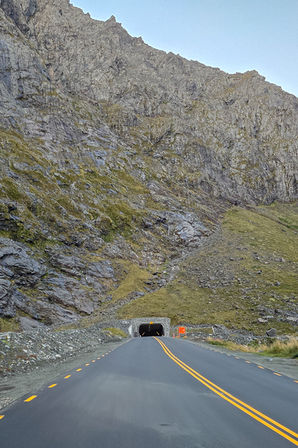 Einfahrt zum Homer Tunnel auf der Milford Road zwischen steilen Felswänden im Fiordland Nationalpark.