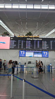 Abflug am Flughafen Stuttgart mit Anzeigetafel und Sicherheitskontrolle zum Barcelona-Wochenende.