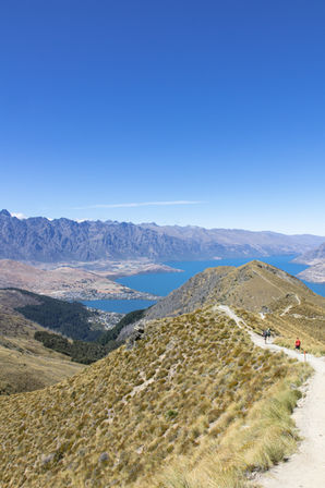 Wanderer auf dem aussichtsreichen Ben Lomond Track mit Lake Wakatipu und Queenstown tief im Tal