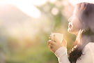 Woman enjoying steaming coffee outdoors