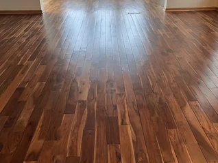 Split image of an empty room’s hardwood floor before and after refinishing, with large text Before and After.
