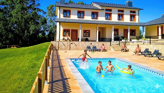 Familias disfrutando de la piscina exterior de Apartamentos Navalin en Tapia de Casariego durante unas vacaciones en Asturias.