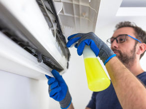 HVAC Repair man cleaning AC