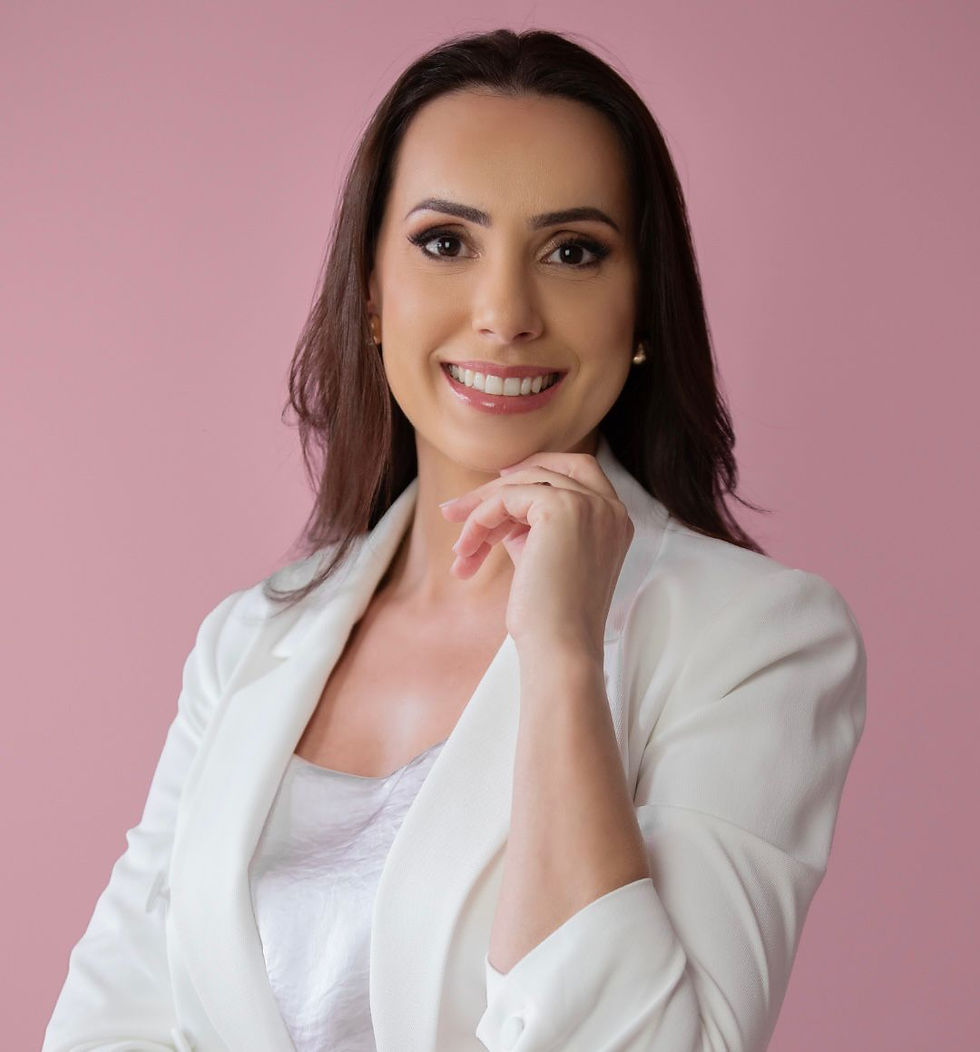Woman smiling in white top against soft pink background