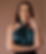 Woman in green dress smiling at the camera against brown background