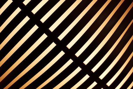 Plafonnier en forme de disque lumineux filtré par une trame en laiton