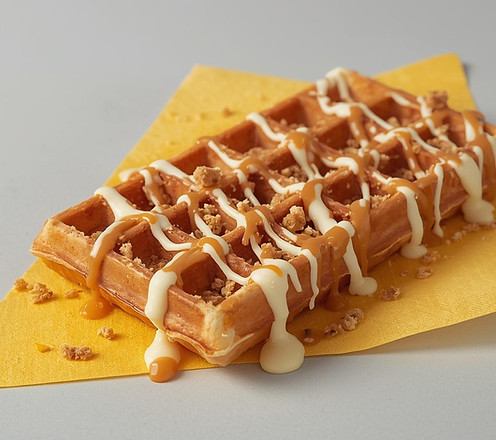 Generate or create a 10 by 15 rectangle waffle drizzled with biscoff sauce, white chocolat