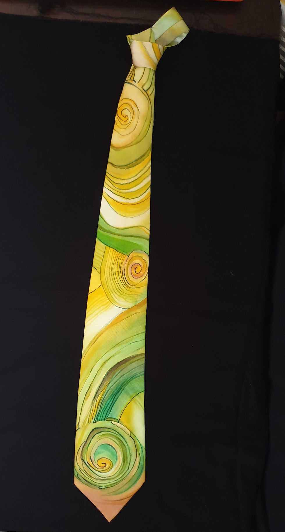 Thumbnail: Hand painted Yellow and green abstract geometric design silk necktie placed against a black background for photography