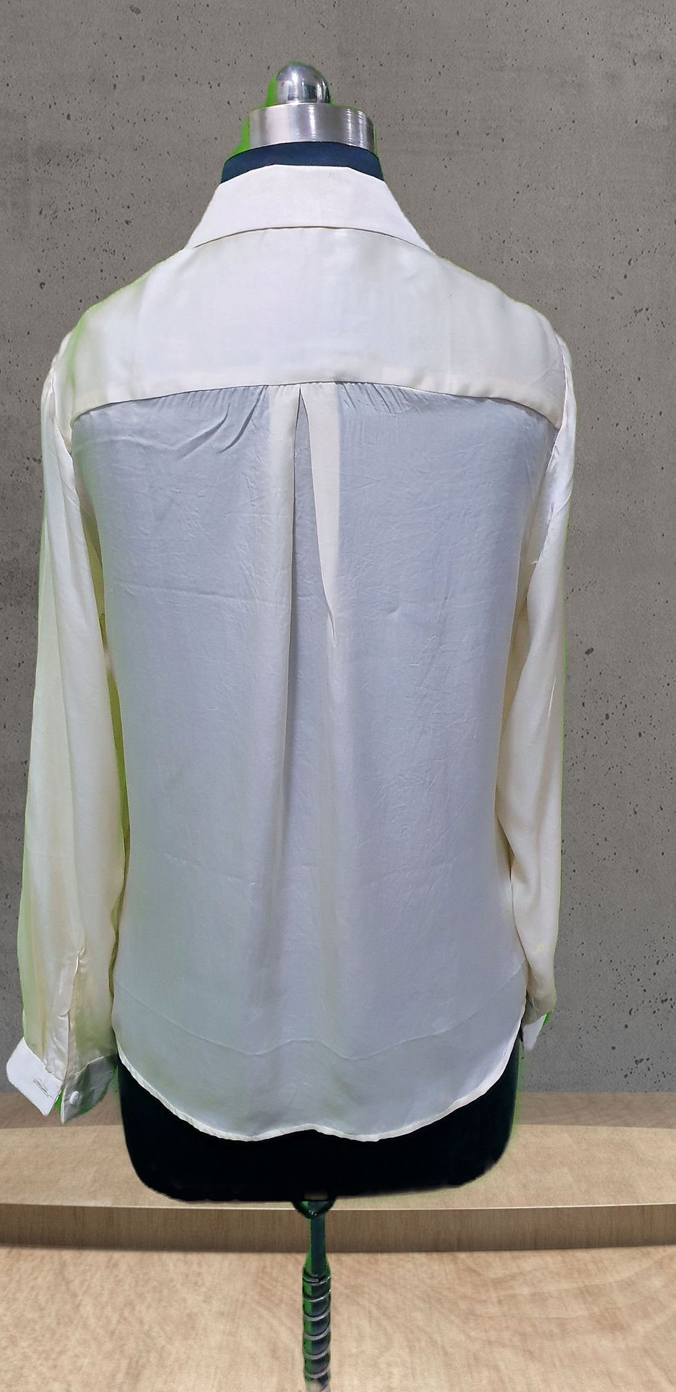 Thumbnail: Rear of a beige silk shirt, hand painted with vibrant floral motifs draped on a mannequin for photography