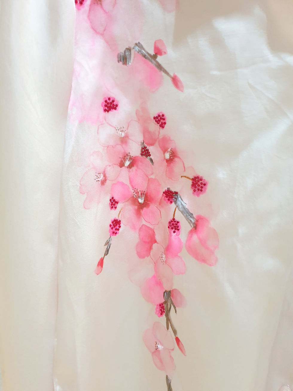Thumbnail: Close up of a luxury hand painted pink silk shirt featuring floral artwork displayed prominently