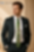Male model posing in a luxury hand painted green silk necktie featuring an abstract circular artistic design on premium silk