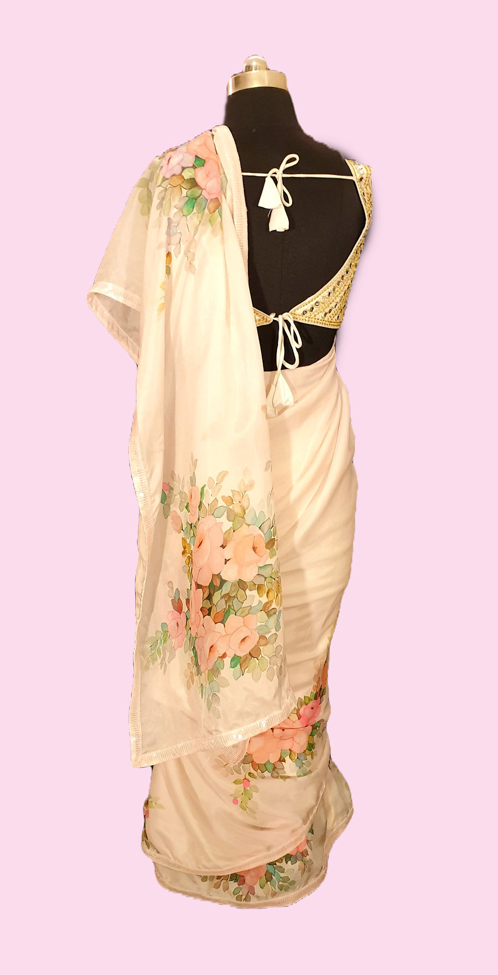 Thumbnail: Beige silk saree hand painted with bunches of pink roses, draped on a mannequin against a pink background