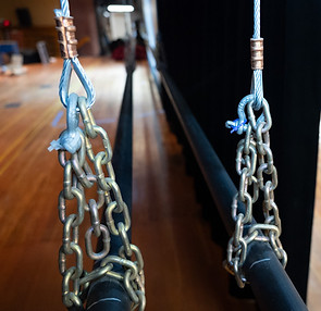 Two pipe battens with chain wrapped around the pipe connected to wire rope thimbles