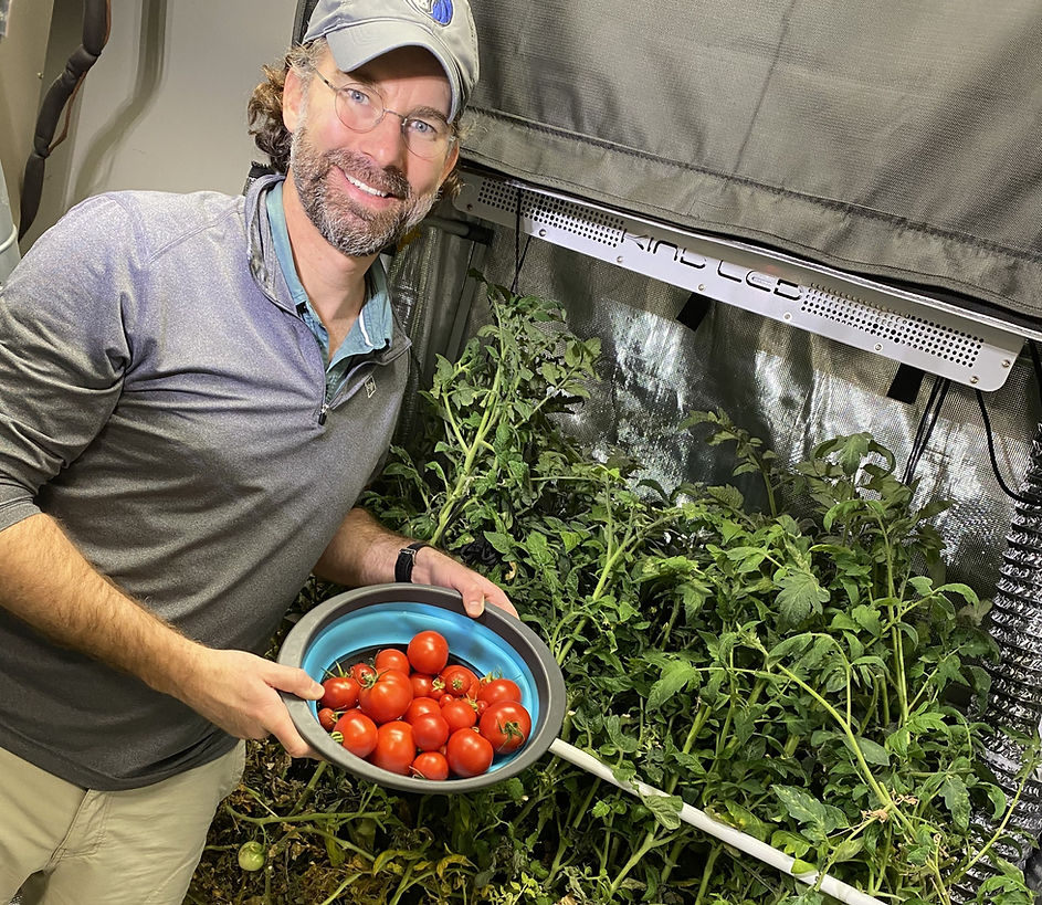 Zach Eccleston, plant attorney, holding a bowl of freshly harvested heirloom tomatoes