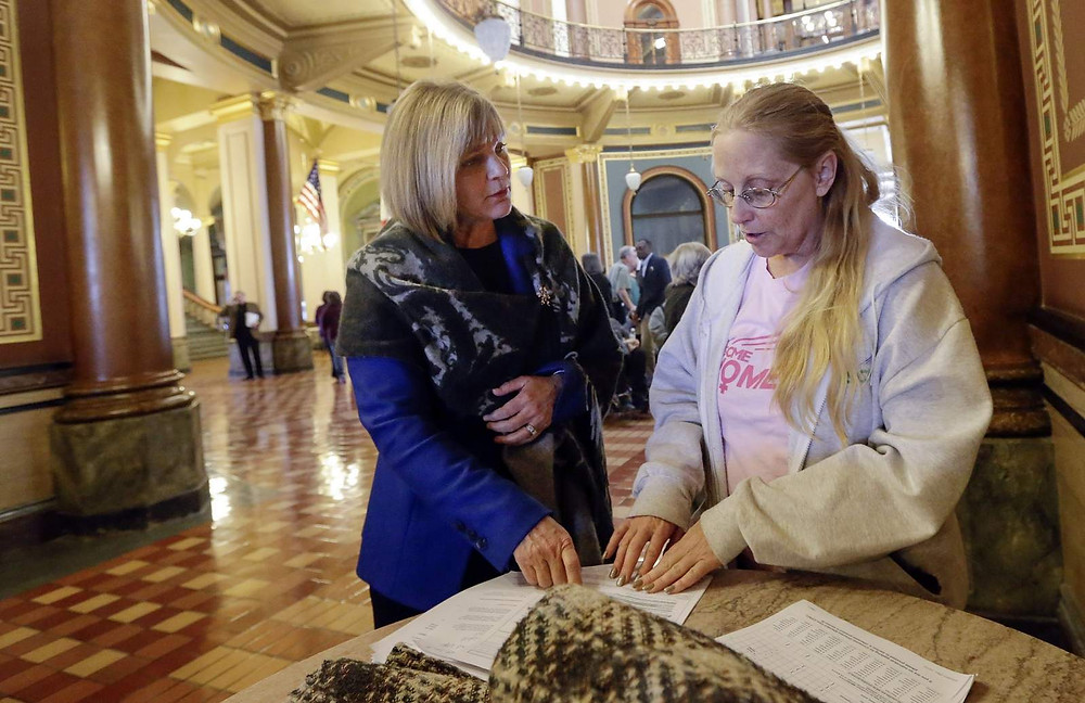 (File Photo) Sen. Liz Mathis listens to Marge Cannon of Garden Grove, Iowa, as she shows her managed care paperwork during a recess in a hearing by the Legislative Health Policy Oversight Committee at the State Capitol in Des Moines, Iowa, on Monday, Nov. 7, 2015. (Jim Slosiarek/The Gazette)
