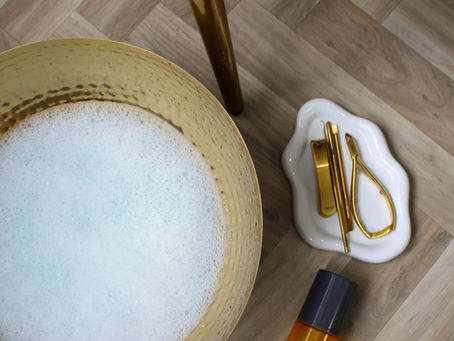 product photography image of set up for pedicure with bowl of soapy water and pedicure products and tools