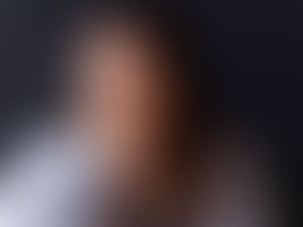 amanda hughes white female long brown hair sat in front of podcast mic with headphones on smiling at camera