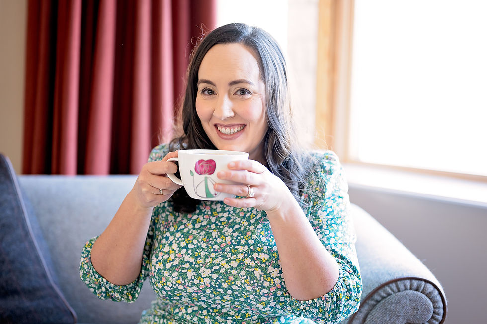 white female with short brown hair and floral shirt drinking tea Claire Cunningham of Word Craft Claire