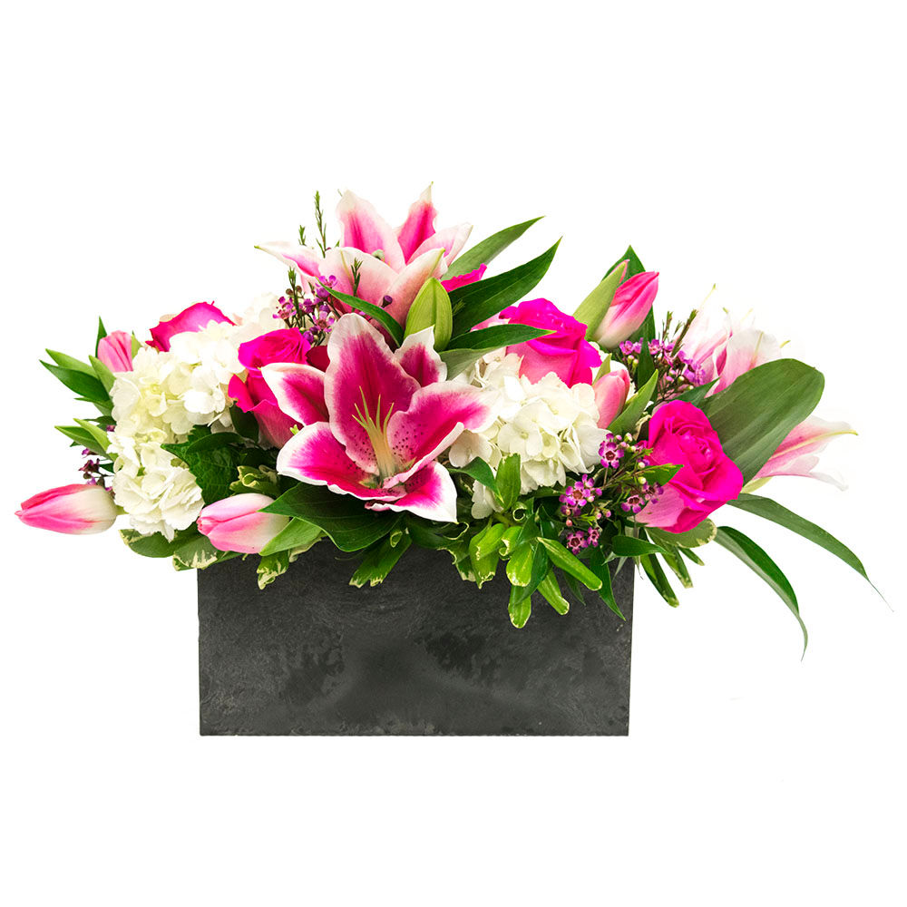 White Hydrangea pink Hybrid Lilies pink Roses pink Tulips and pink Waxflower with Italian ruscus and pittosporum