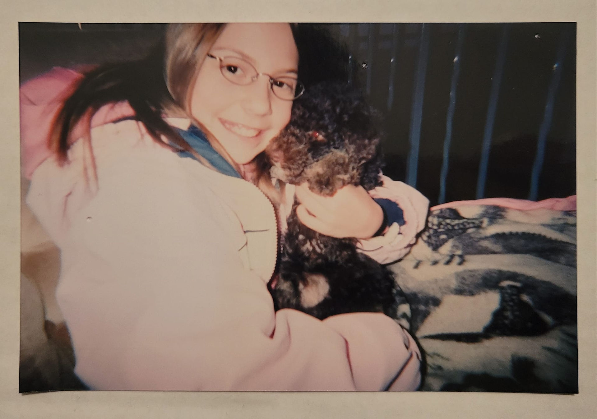 Best Pet Canvas owner, Robyn, as a little girl excitedly smiling at the camera while caressing a 10 week old Riley in her arms. Riley's face is touching her face.