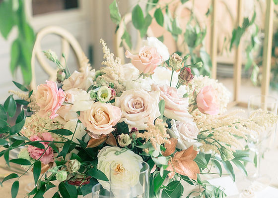 Garden-style wedding floral centerpiece with soft pastel blooms and greenery by Flowers by Jo-Ann.
