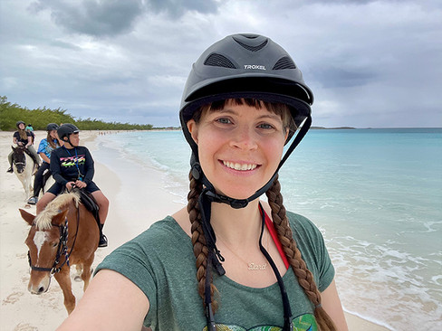 woman horseback riding on the beach