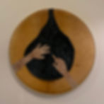 leather artwork with hands touching a dark, star-filled shape