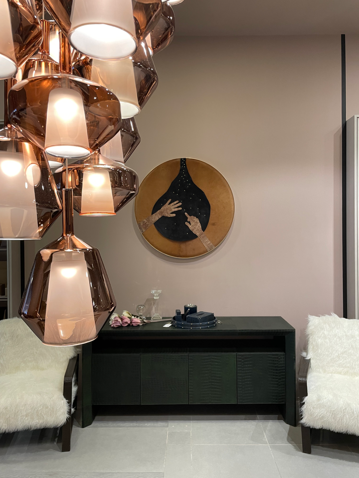 leather artwork of hands reaching in a modern room