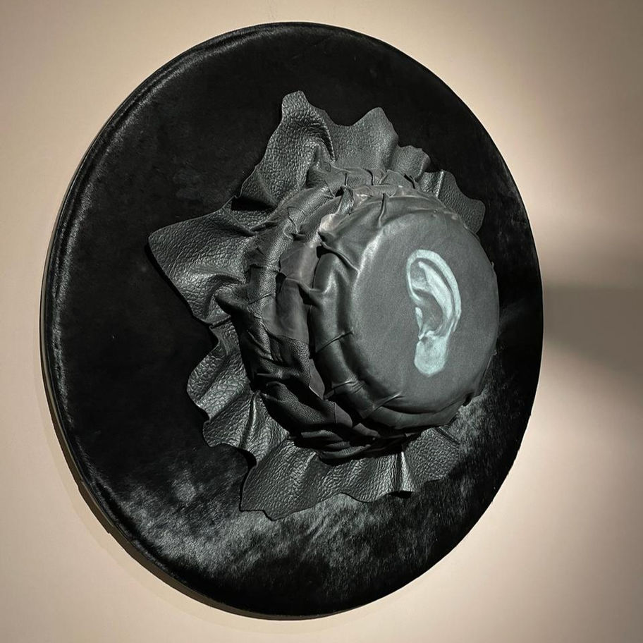 Abstract artwork: dark circular form with ruffled texture and ear detail