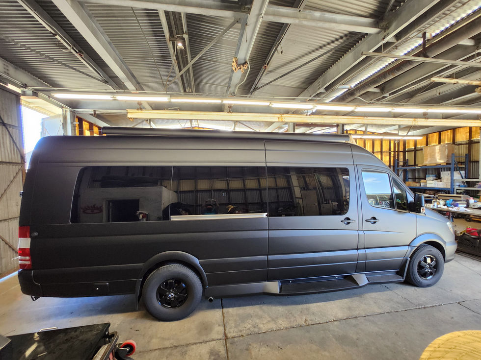 Sprinter Van with matte black graphics wrap in warehouse shop