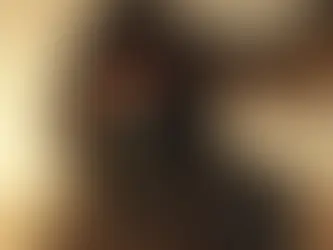 Close-up portrait of a young desert wanderer wrapped in flowing robes and a wind-blown scarf, his intense eyes glinting beneath the fading light of the desert horizon.