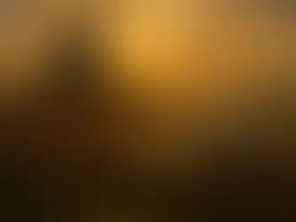 A golden sunset illuminates the fortified port city of Portjaw, nestled along a wide bay. Tall stone walls and red-roofed buildings cluster around a towering black ruin — the shattered spire of Zargath’s tower — rising above the city. Merchant ships with white sails drift across calm waters, while distant hills fade into mist beneath a warm, glowing sky. The scene captures both the city’s beauty and its haunted history.