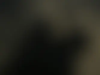 A dark-armored knight sits atop a black warhorse beneath a stormy sky. The knight’s spiked helm and layered plate armor gleam faintly in the dim light, and a tattered black pennon flutters from his lance. The horse stands firm amid swirling clouds, its armor catching the same somber tones as the storm, evoking a mood of power, menace, and foreboding calm before battle.