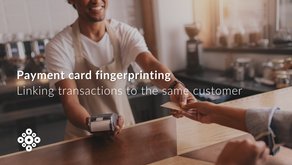 Barista smiling, holding payment device and handing card to customer out of view across counter in café. Text: Payment Card Fingerprinting - linking transactions to the same customers