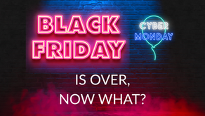 Neon text Black Friday and Cyber Monday is over, now what? on a dark brick wall, with red smoke below