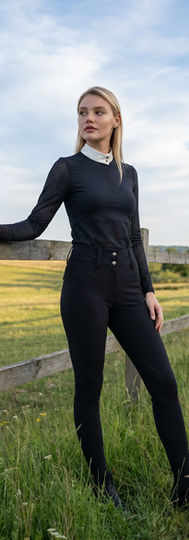 Designed for performance and ventilation, this long-sleeve equestrian top features breathable mesh sleeves and laser-cut pinhole detailing. Finished with a crisp contrast collar and half-zip entry, it offers a refined, functional silhouette for riding and training.