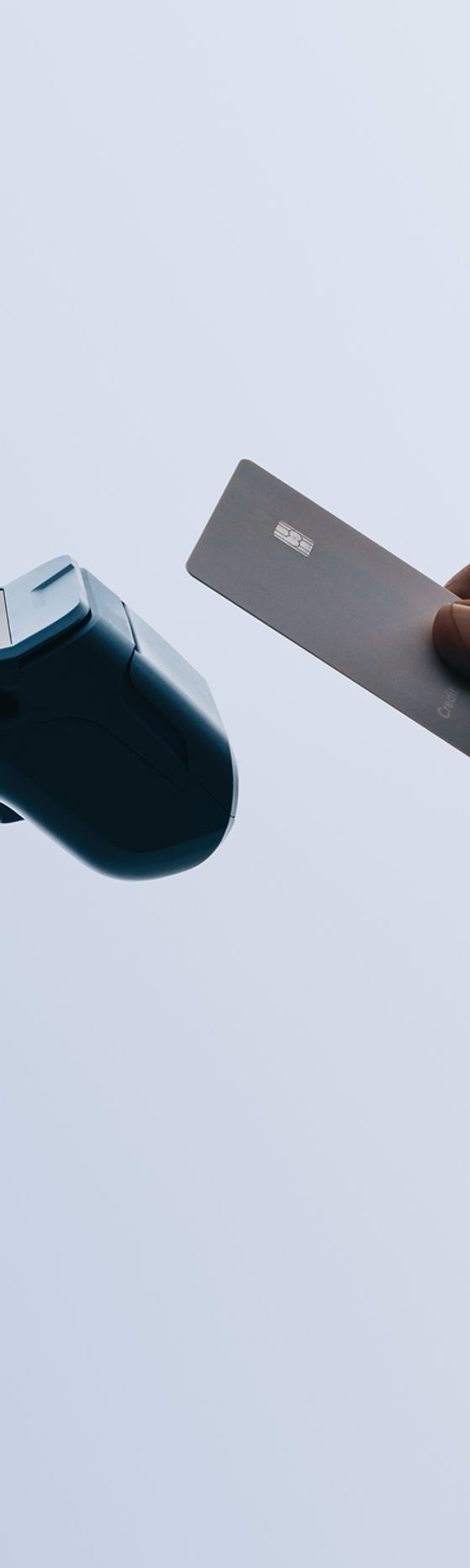 Hands scan a bank card for contactless payment at a checkout. The card reader enables conv