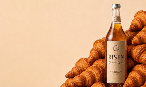 Risen Croissant Liqueur surrounded by croissants, the ingredients used to make the spirit.