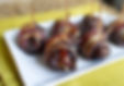 Ciruelas rellenas de nuez envueltas en tocino.