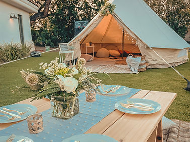 Buffalo backyard glamping picnic setup with low tables, cozy seating, and styled décor for weddings and celebrations