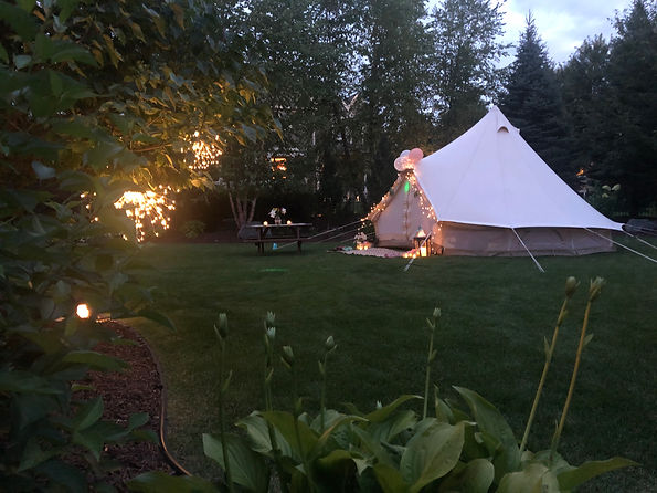 Backyard glamping tent with outdoor projector and lounge seating for a Buffalo NY movie night rental