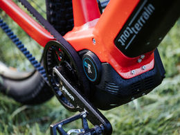 Een close-up van de motor/aandrijving van een rode fiets, de Tout Terrain Divide, met de Motor.Gearbox.Unit van Pinion, die aandrijving en motor in één unit combineert.